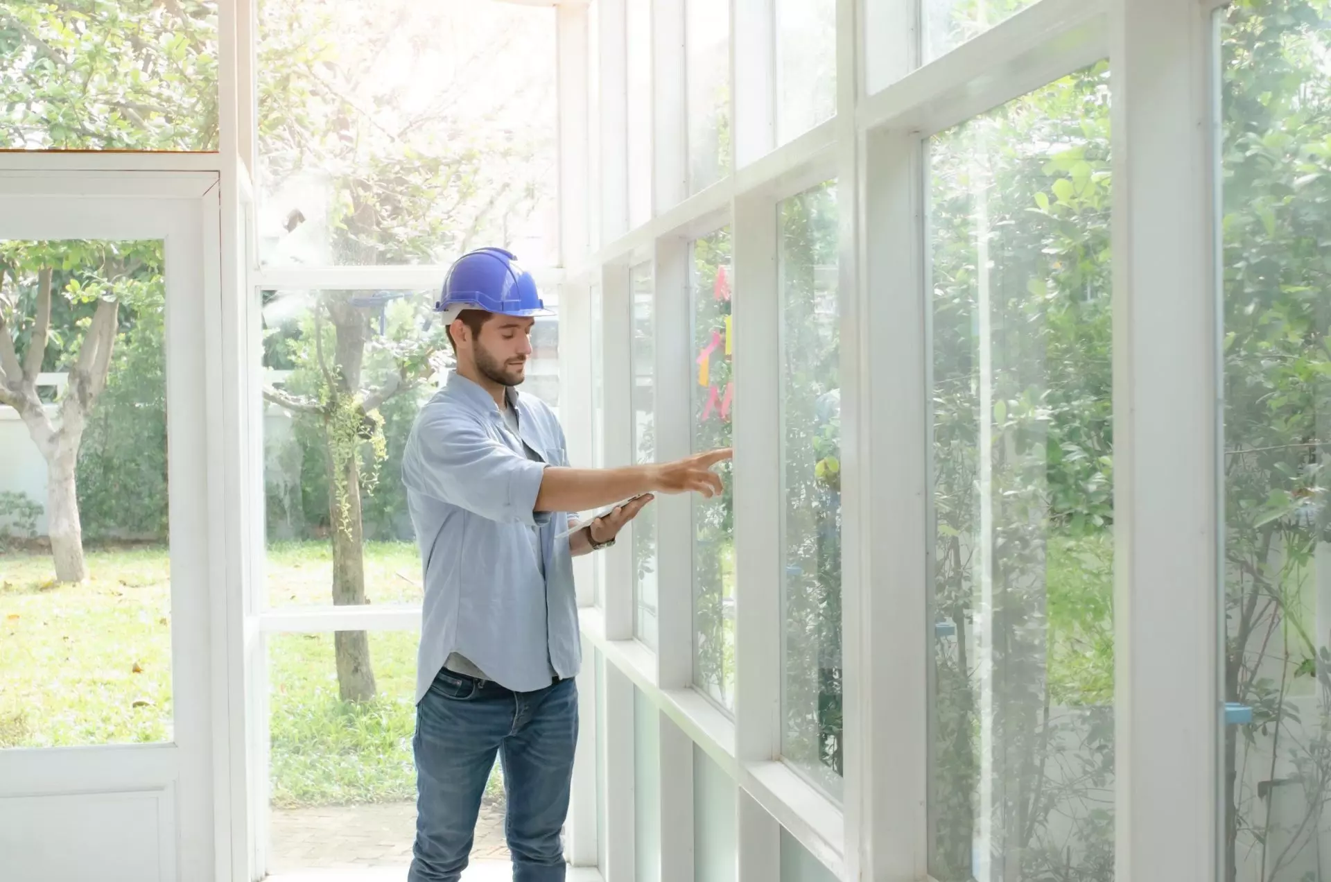 man wearing hardhat installing window