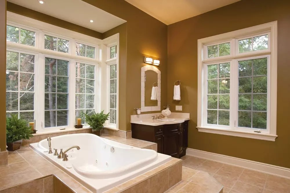 Modern brown colour bathroom with casement windows and Jacuzzi bath