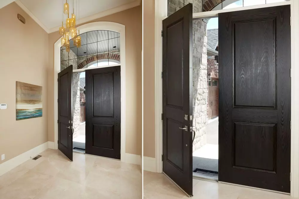 slightly open main entrance doors in black colour - solid wood doors